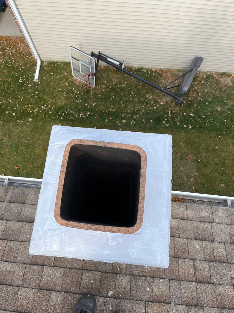 The same chimney crown coated with white sealant, seen from above