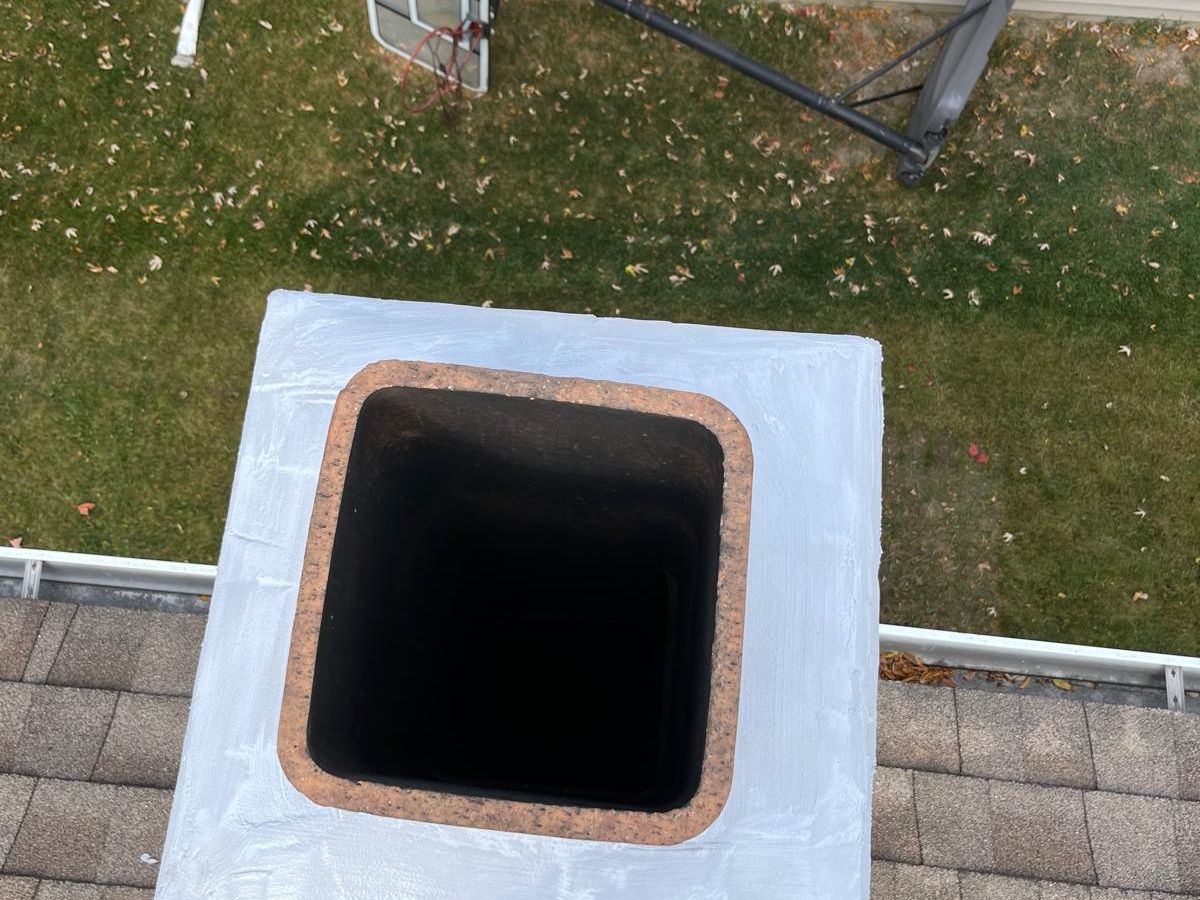 Chimney crown coated with white sealant, seen from above